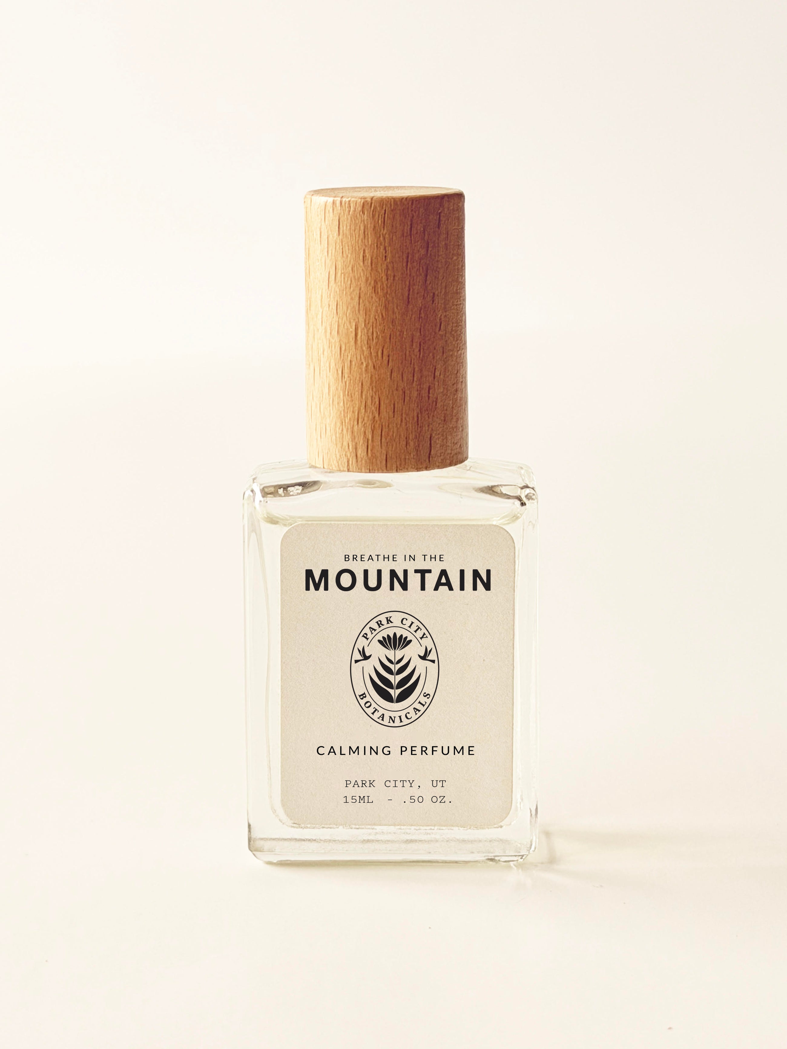 Perfume bottle with wooden cap on a light beige background