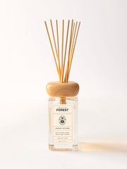 Reed diffuser with wooden sticks and a clear bottle labeled 'Forest' on a white background