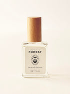 Perfume bottle with wooden cap on a light beige background