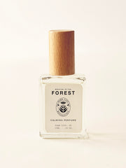 Perfume bottle with wooden cap on a light beige background