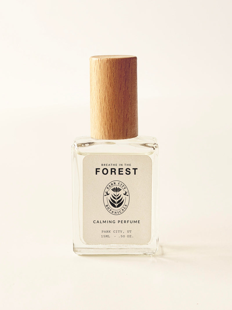 Perfume bottle with wooden cap on a light beige background