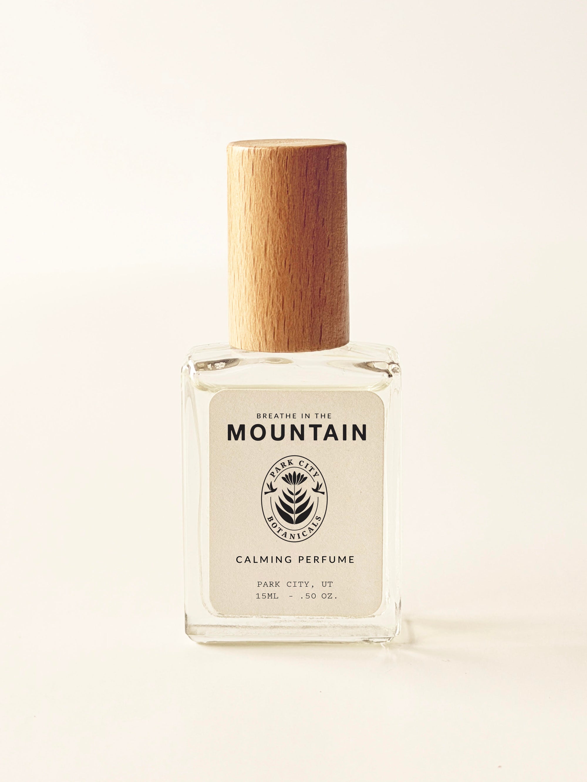 Perfume bottle with wooden cap on a light beige background