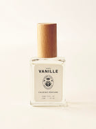 Perfume bottle with wooden cap on a light beige background