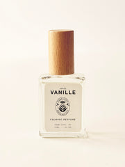 Perfume bottle with wooden cap on a light beige background