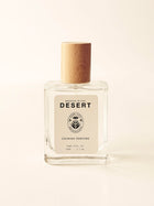 Perfume bottle labeled 'Breathe in the Desert' on a light beige background