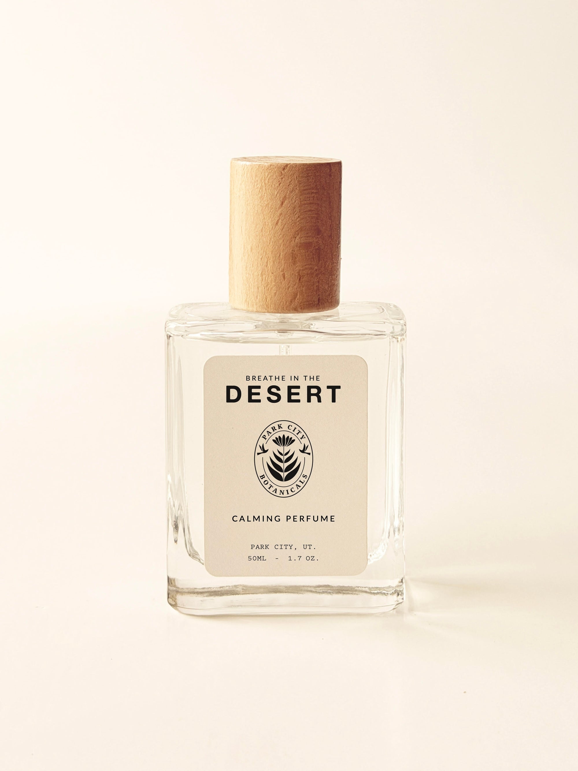 Perfume bottle labeled 'Breathe in the Desert' on a light beige background