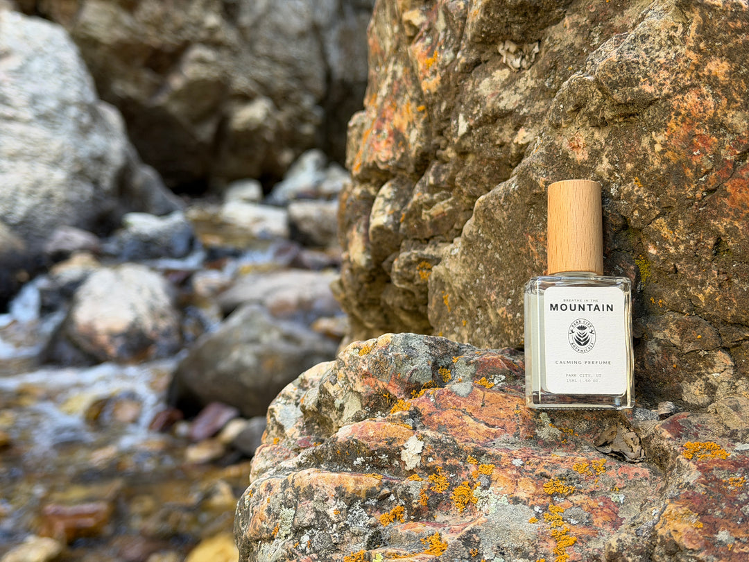 Perfume bottle labeled 'Mountain' on a rocky surface