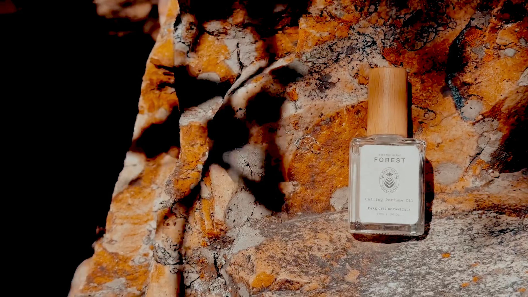 Bottle of Park City Botanicals Forest perfume in a fall rock background